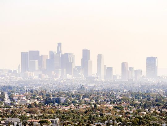 An extreme wide shot of the city of Los Angeles, California. The city’s downtown is covered in a haze.