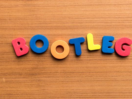 The word "BOOTLEG" spelled out in colorful foam letters—red, blue, orange, and yellow—on a wooden surface.
