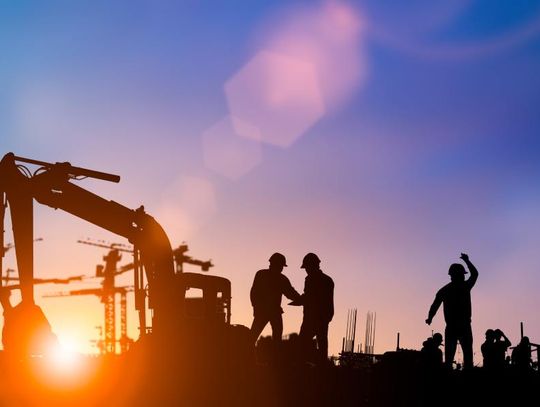 A silhouette of an engineer and construction teams working together at the site for an industrial project.
