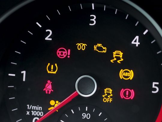 The tachometer of a car with all of the dashboard warning lights activated, including seat belt and TPMS alerts.