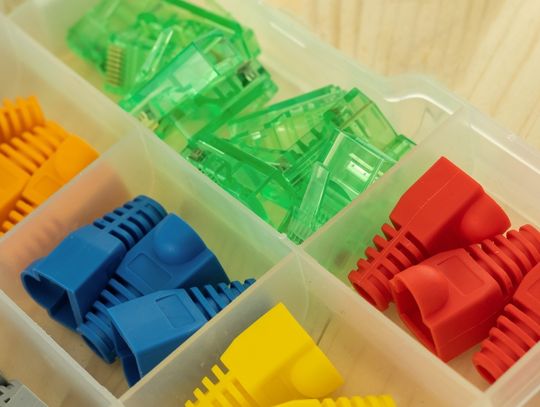 A close-up view shows a plastic organizer filled with various plastic connector caps in different colors.