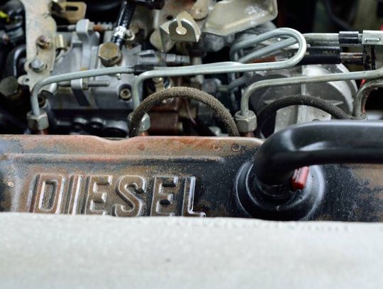 Close-up of a rugged steel and iron diesel engine. The word "DIESEL" is stamped on the top of the engine.