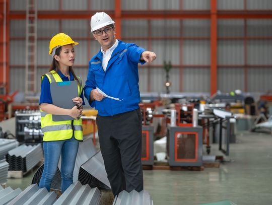 Safety training session at a construction site with two professionals discussing the industrial environment.