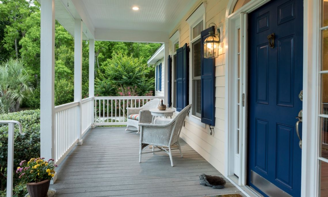 Comfort-Focused Upgrades for Mississippi Homes A southern Mississippi home with a large, wrap around front porch. The porch has two white wicker chairs.