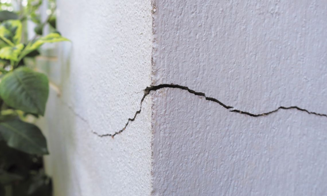 Common Issues With Your Home’s Foundation To Be Aware Of A closeup on the corner of a home's foundation. There is a very noticeable crack running along the concrete.