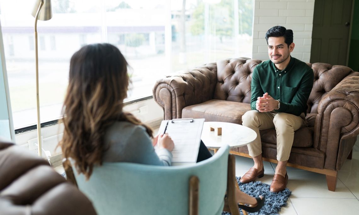 Considerations When Setting Up a Therapy Practice Two people are sitting across from one another. One is holding a clipboard and the other is not holding anything.