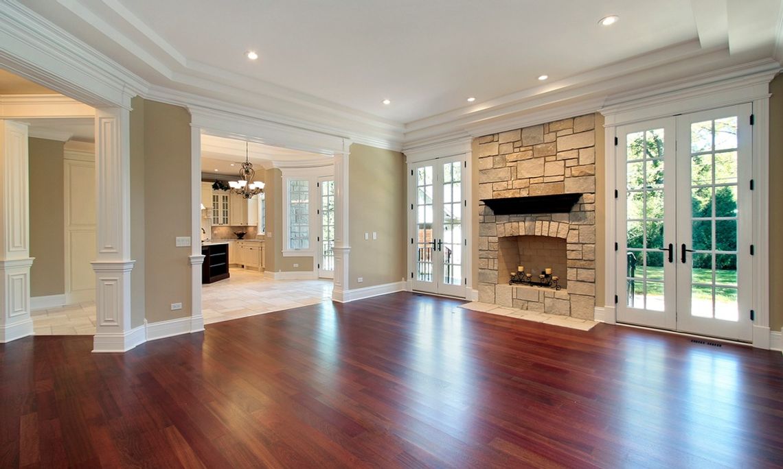 Designing a Home That Ages Beautifully Over Time A living room in a residential home. The floor is made of hardwood and there is a stone fireplace against the wall.