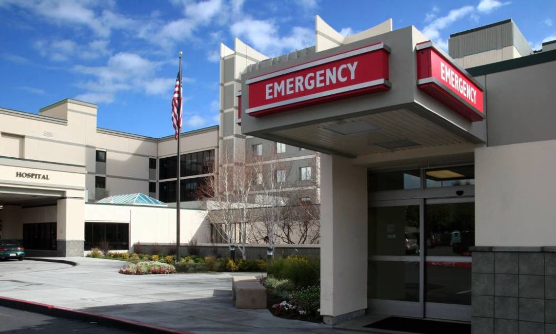 The entrance to the emergency room at a hospital is marked by a red and white sign that says EMERGENCY on it.