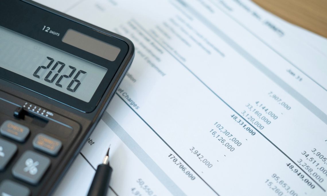 How To Avoid Exceeding Your Budget in Your Household A calculator has the number "2026" on its screen as it sits on a stack of bills. A pen sits next to it.