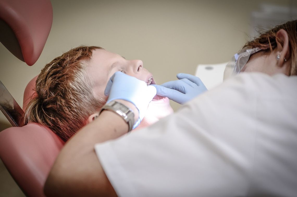 dentist looking in mouth of child