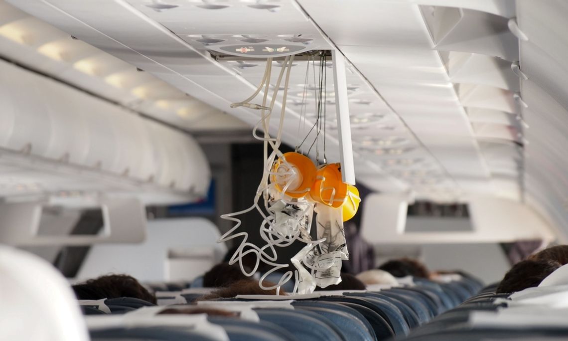 The Role of Solenoid Valves in the Aerospace Industry Several yellow oxygen masks with white tubing drop from the aircraft cabin ceiling above seated passengers.