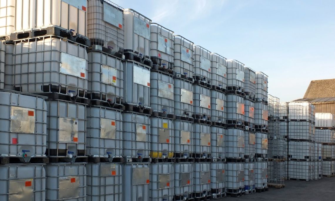 Stacks of intermediate bulk containers on pallets in an industrial yard wait to be cleaned or recycled for further use.