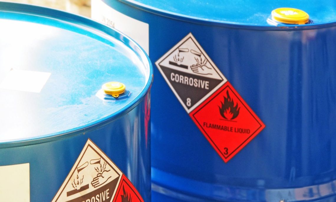What You Need To Know About Chemical Storage on Work Sites A closeup on two large, blue metal drums full of chemicals. There are warning stickers on the side of the drums.