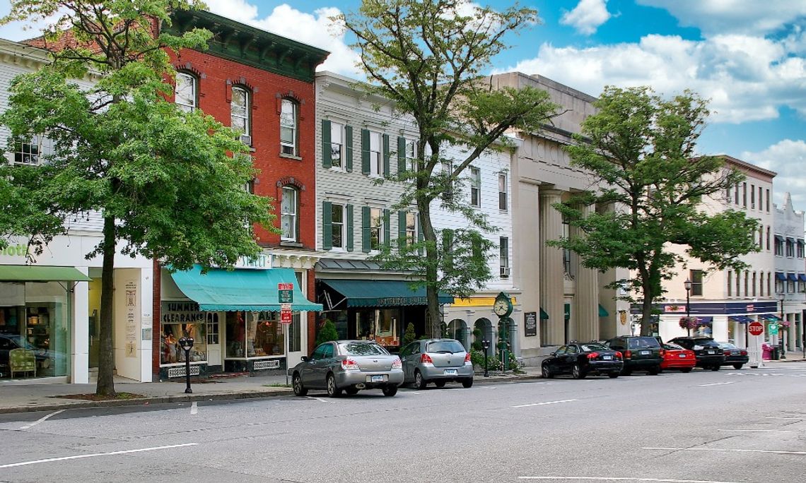 Why Small Towns Offer Big Business Opportunities A small downtown area in a little town with thriving business storefronts. There are cars parked in front of them.